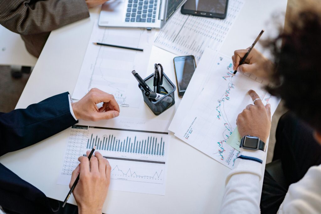 Formación de Empresas Business team analyzing financial charts and graphs during a collaborative meeting.
